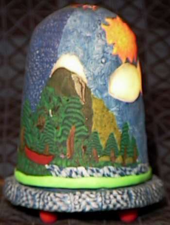 a lamp depicting a mountain, trees and water
